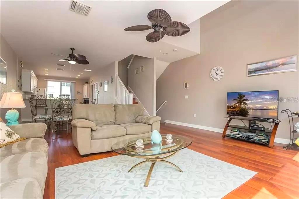 A living room with hardwood floors, a glass coffee table, and a ceiling fan — 8920 DUVAL LANE UNIT B15, SARASOTA, FL