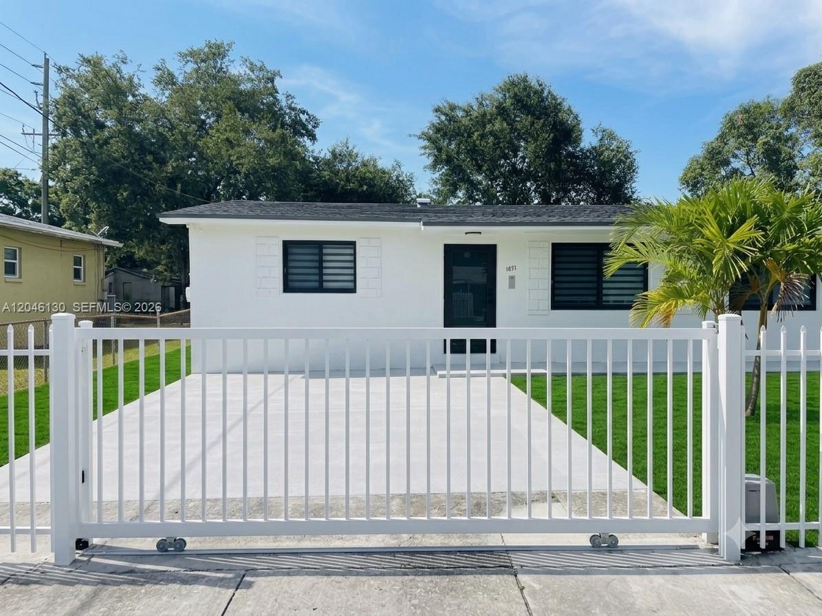 A white single-story house features a black front door, dark windows, and a white fence — 1855 NW 93rd Ter # 2, Miami FL 33147, MIAMI, FL
