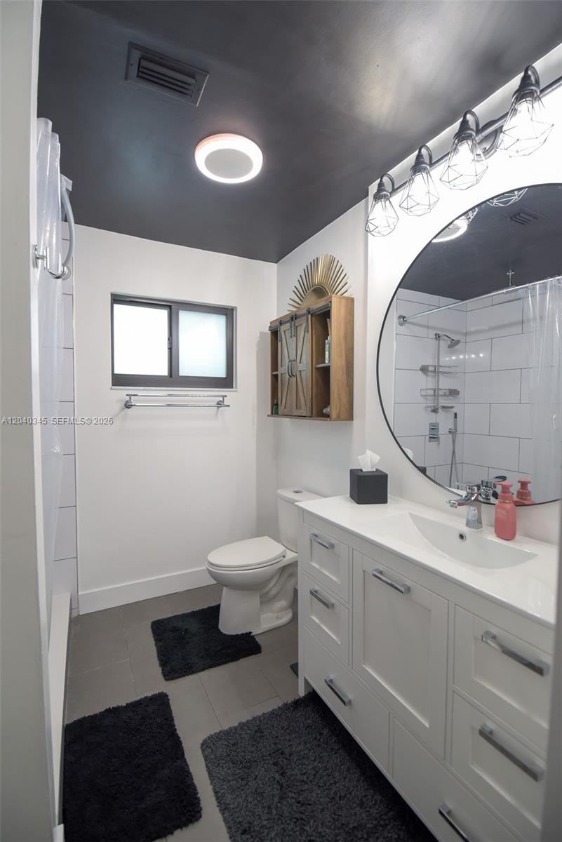 A bathroom features a white vanity, a round mirror, a toilet, and a dark ceiling — 8356 NW 37th Pl # 9, Sunrise FL 33351, SUNRISE, FL