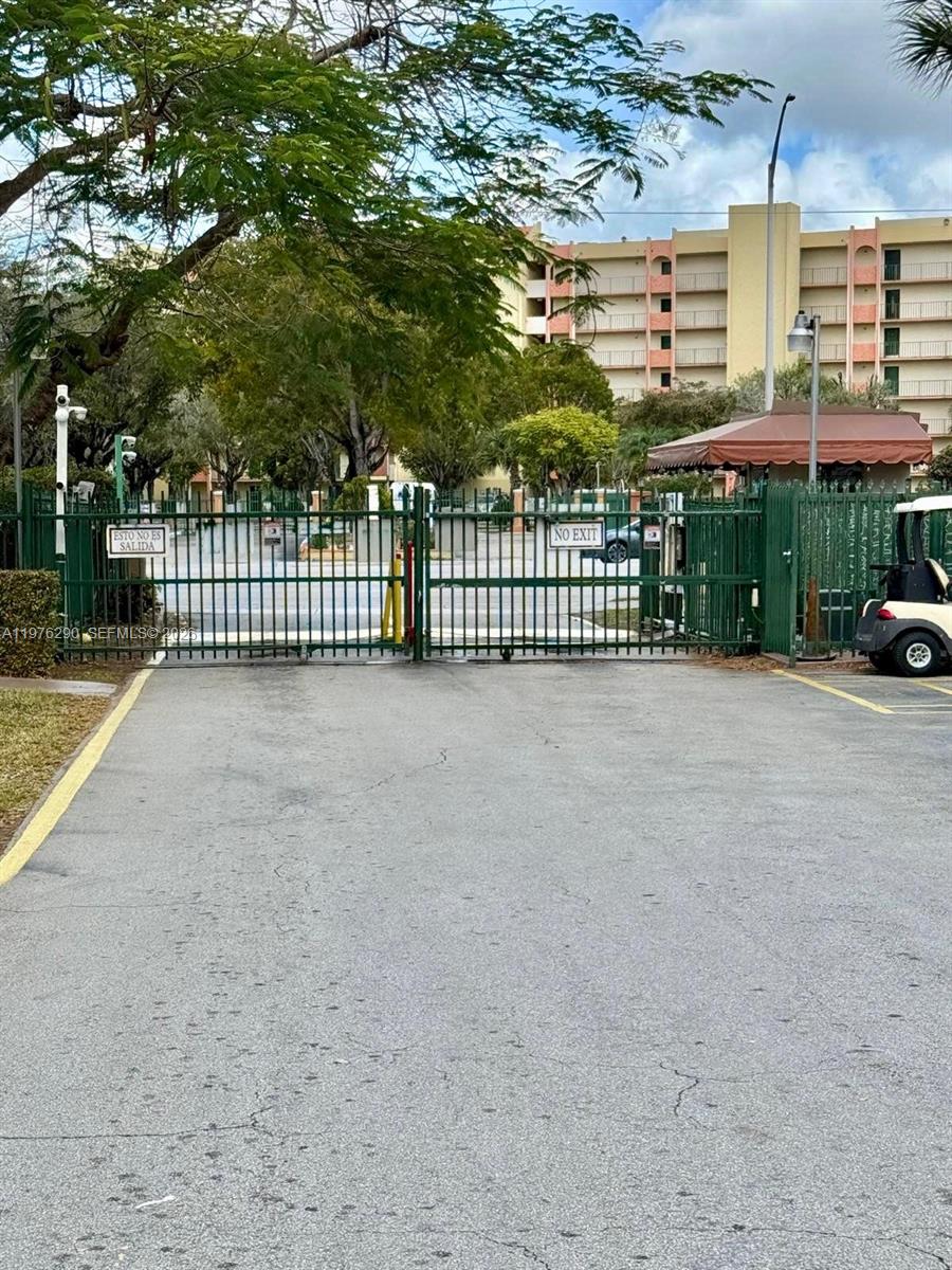 A gated entrance with a metal fence leads to a residential building in the background — 9400 WEST FLAGLER ST # 312, Miami FL 33174, MIAMI, FL
