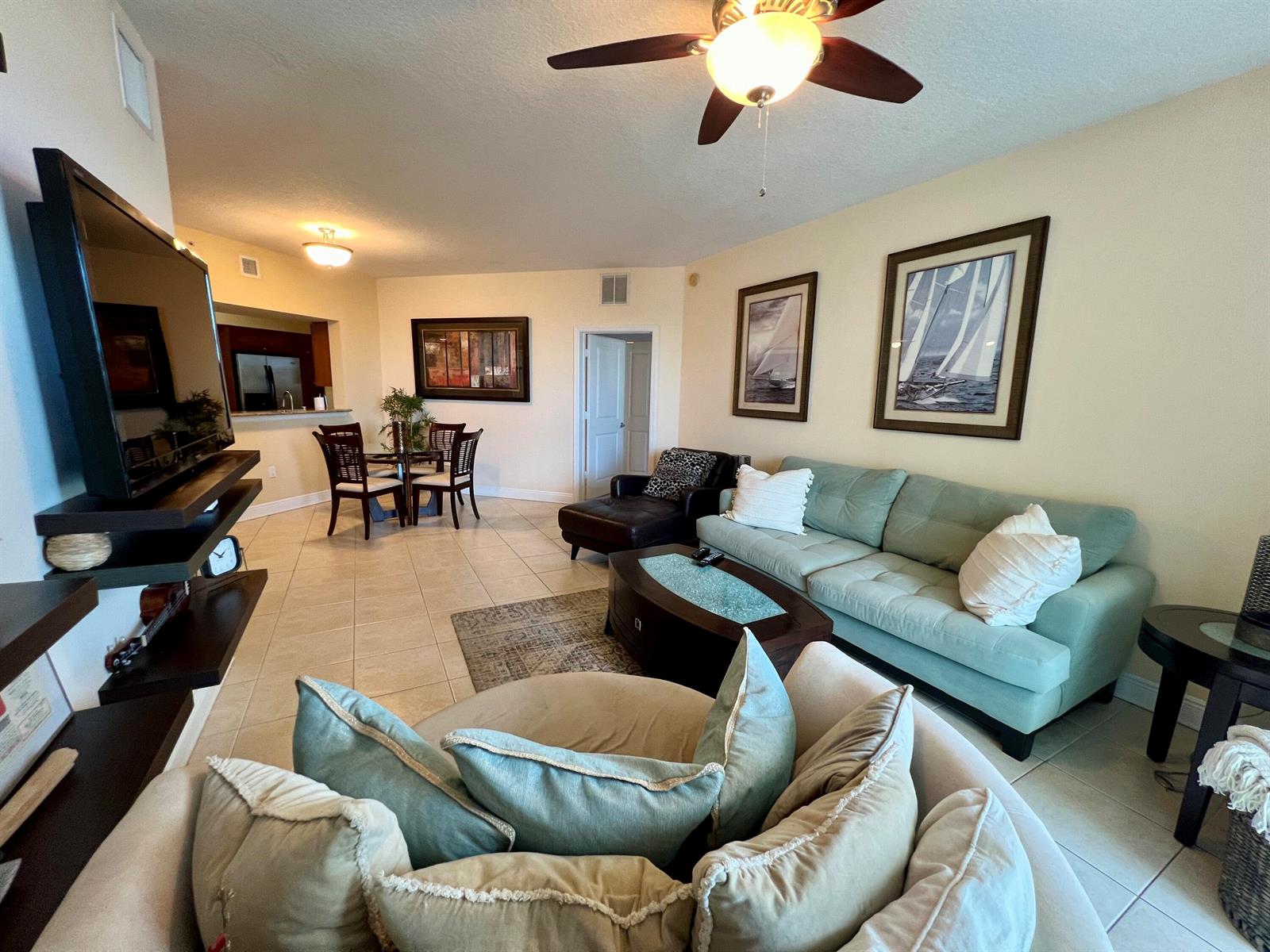 A living room features a light blue sofa, a round chair, and a dining area — 975 NW Flagler Avenue, Stuart FL 34994, STUART, FL