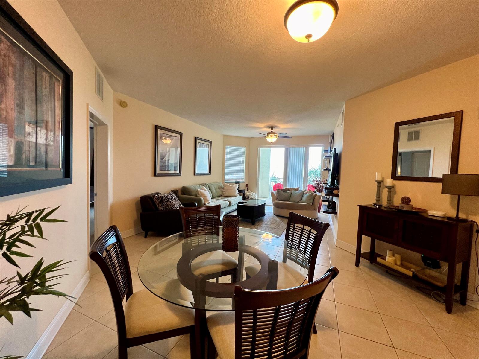 A dining area with a glass table and chairs opens into a living room — 975 NW Flagler Avenue, Stuart FL 34994, STUART, FL
