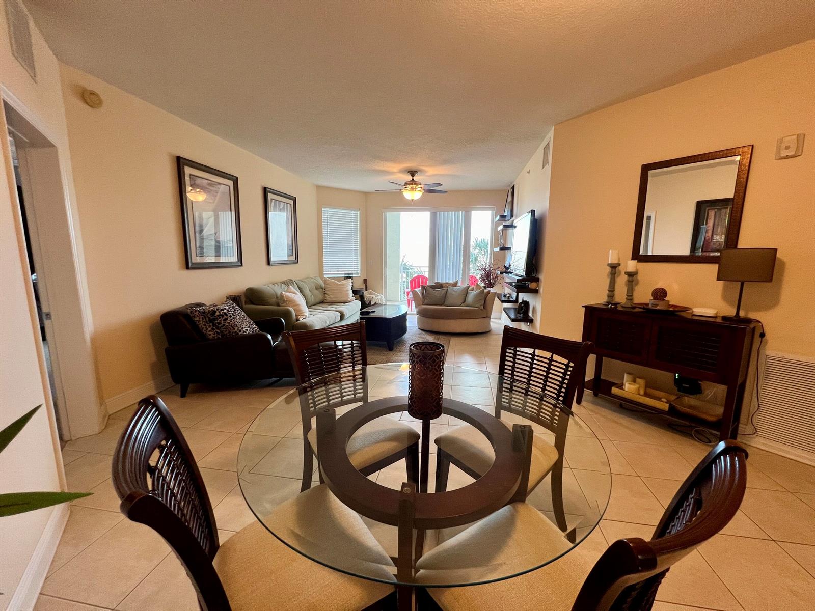 A dining area with a glass table and chairs opens into a living room with tile floors — 975 NW Flagler Avenue, Stuart FL 34994, STUART, FL