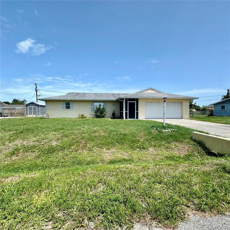A single-story house with a light yellow exterior, a gray roof, and a two-car garage — 340 PEARY ROAD, VENICE, FL