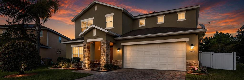 A two-story house with a stone-accented entryway, a two-car garage, and a paved driveway — 2722 BIG TIMBER DRIVE, KISSIMMEE, FL