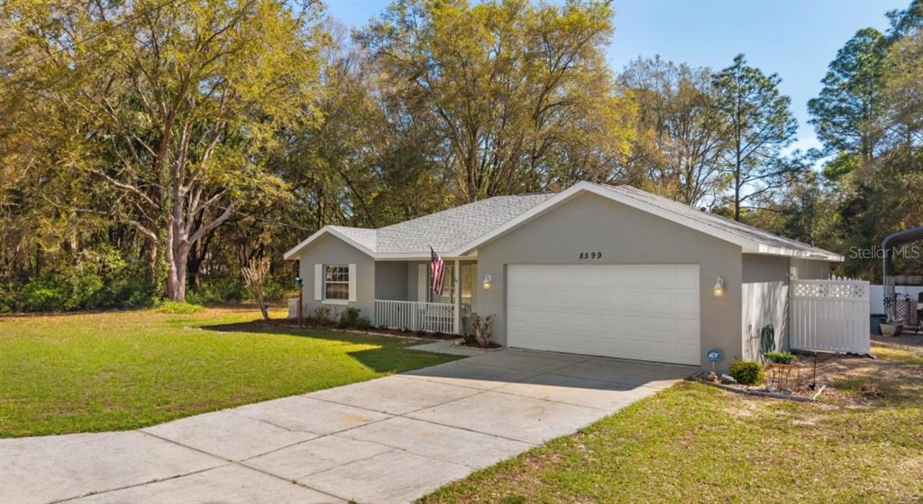 A single-story house with a gray exterior, a two-car garage, and a front porch — 8599 N MESSINA LOOP, CRYSTAL RIVER, FL