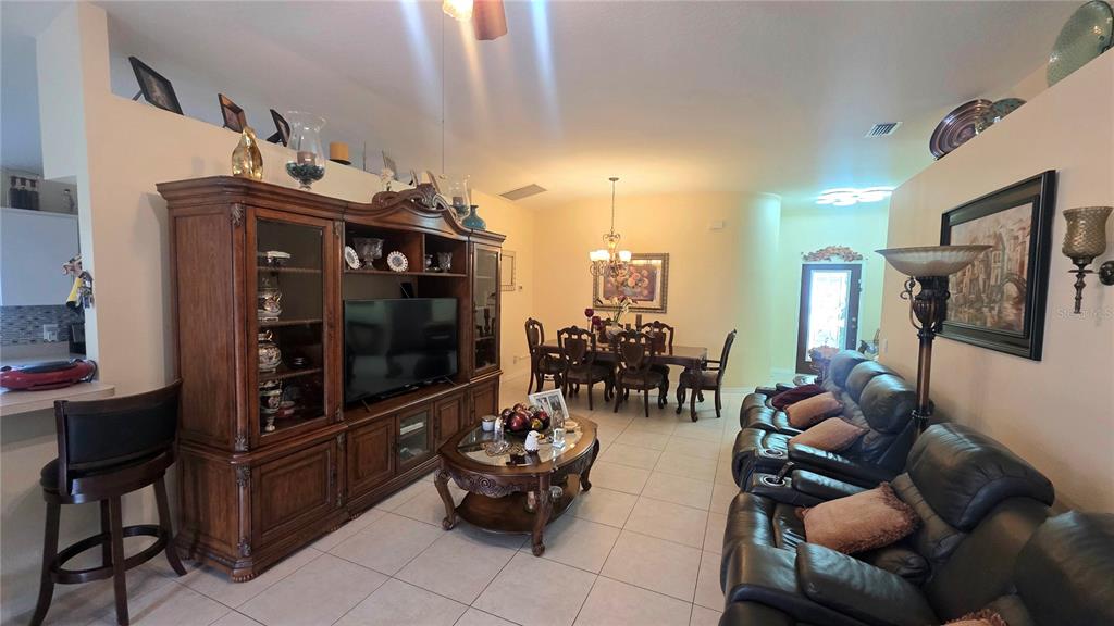 A living room and dining area feature tile floors, a large entertainment center, and furniture — 9708 WHITE BARN WAY, RIVERVIEW, FL