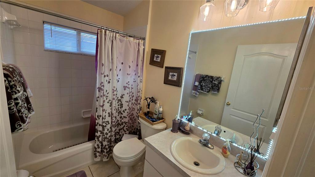 A bathroom features a shower-tub combination, a single vanity, and a large illuminated mirror — 9708 WHITE BARN WAY, RIVERVIEW, FL