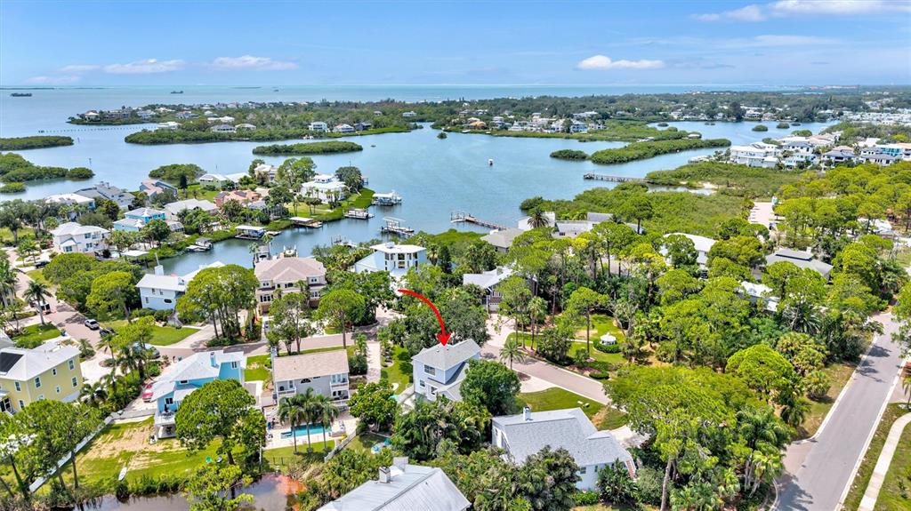 An aerial view shows a residential neighborhood with houses surrounded by trees and water — 760 SOUNDVIEW DRIVE, PALM HARBOR, FL