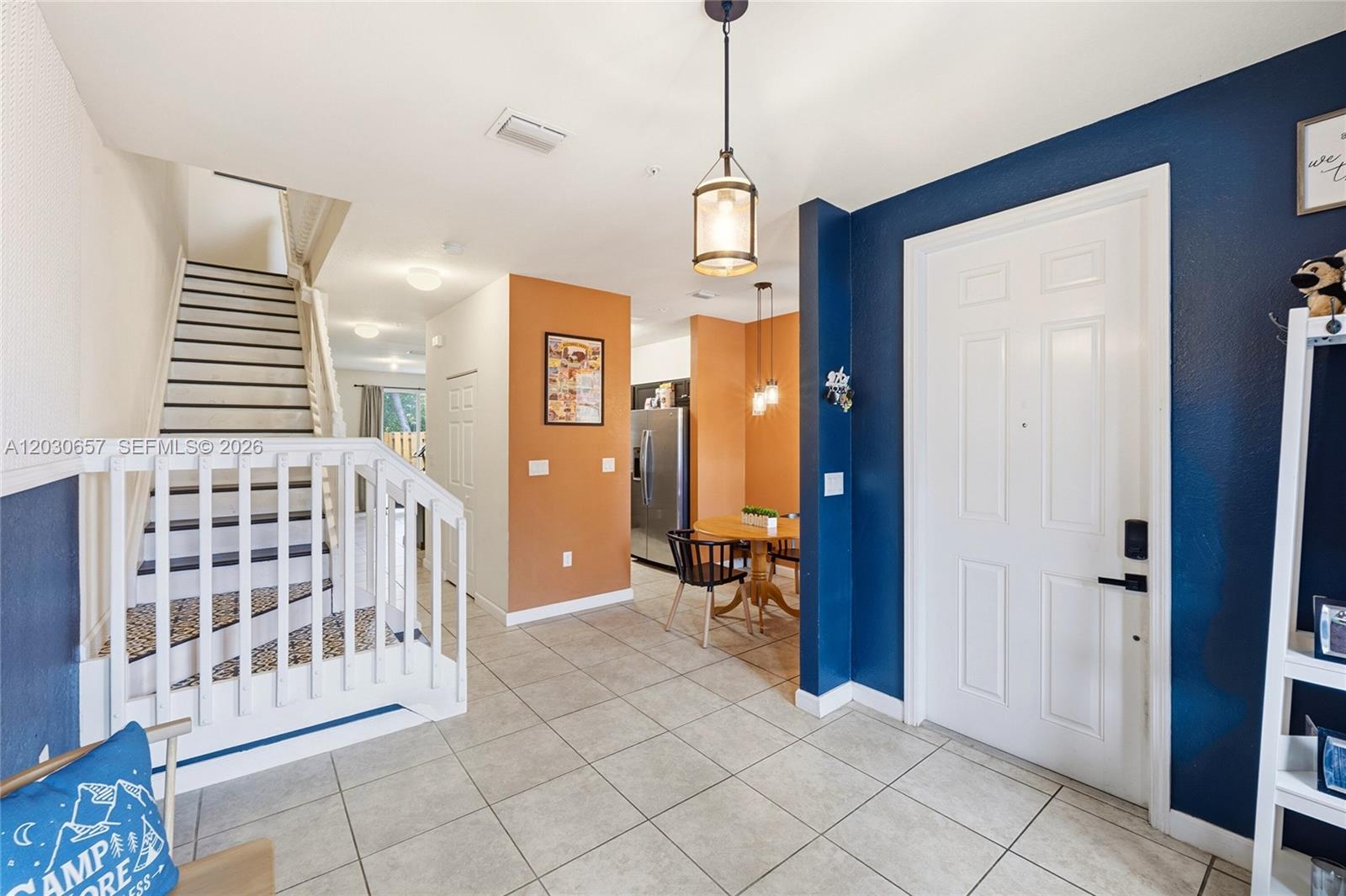 An entryway features a white staircase, tiled floors, and a blue accent wall — 142 SE 28th Ter # 6, Homestead FL 33033, HOMESTEAD, FL