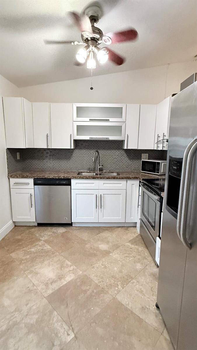 A kitchen with white cabinets, stainless steel appliances, granite countertops, and tiled flooring — 4313 NW 6th Avenue, Pompano Beach FL 33064, POMPANO BEACH, FL
