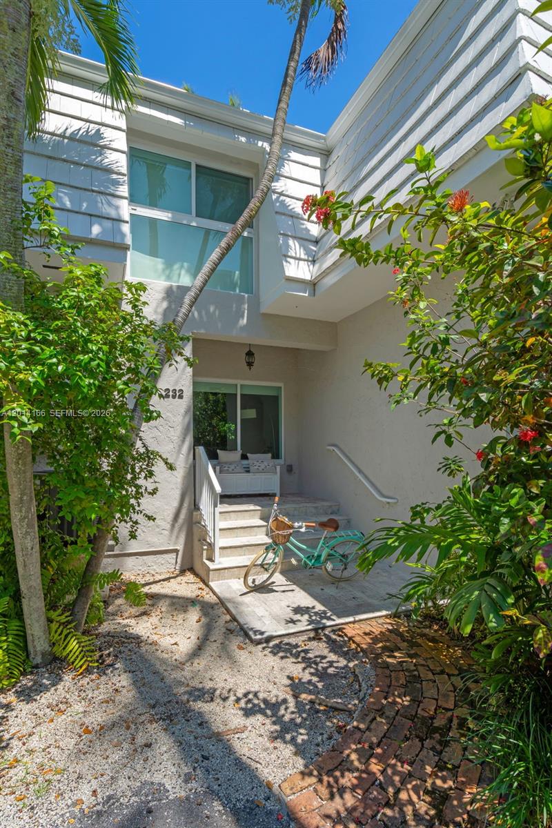 The exterior of a two-story residential building features a front entrance with steps and a bicycle — 232 Sea View Dr # 108, Key Biscayne FL 33149, KEY BISCAYNE, FL