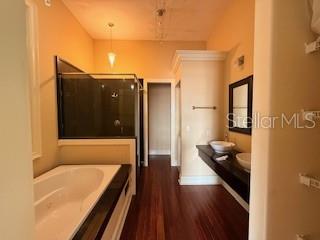 A bathroom features a soaking tub, a glass-enclosed shower, and a double vanity with sinks — 44 S MAGNOLIA AVENUE, OCALA, FL
