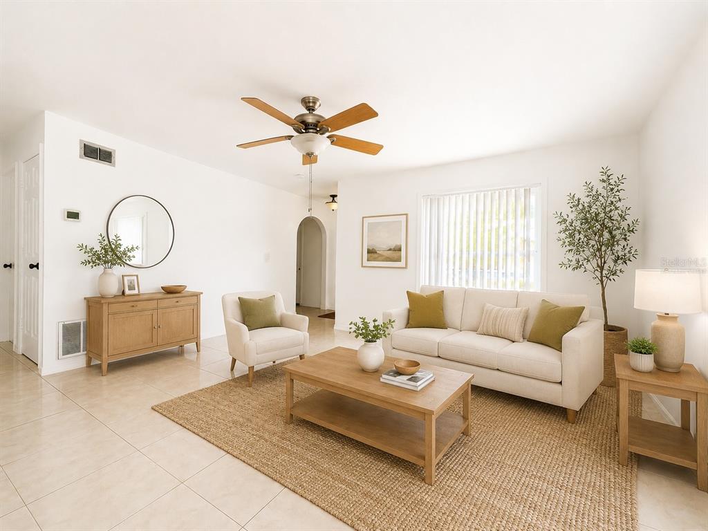 A bright living room features light tile floors, a neutral sofa, and a wooden coffee table — 714 WEST COURT, LONGWOOD, FL