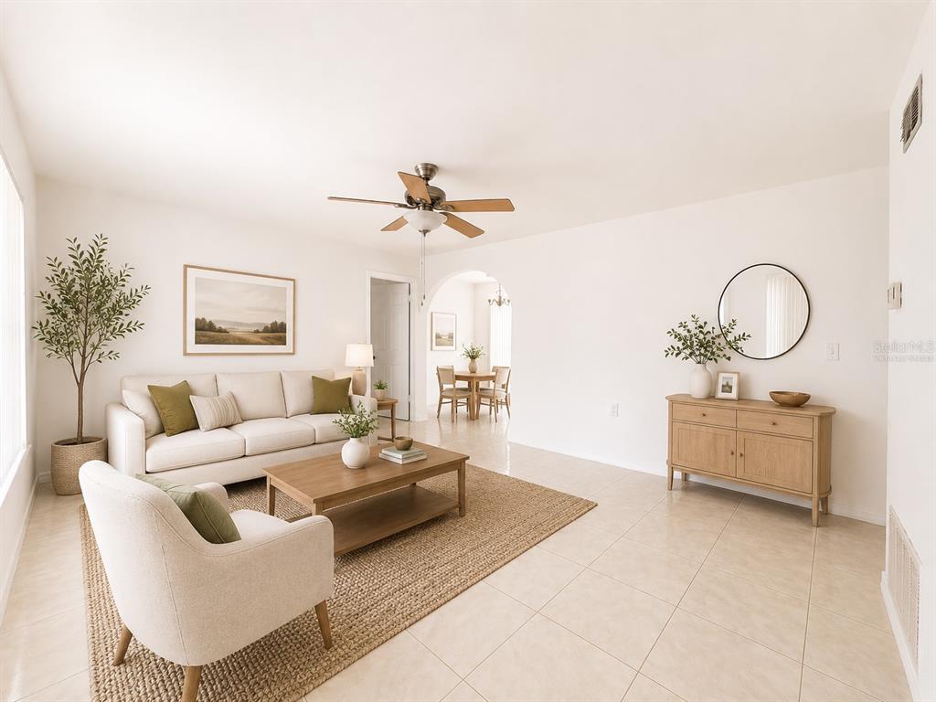 A bright living room features a beige sofa, an armchair, a coffee table, and tile flooring — 714 WEST COURT, LONGWOOD, FL