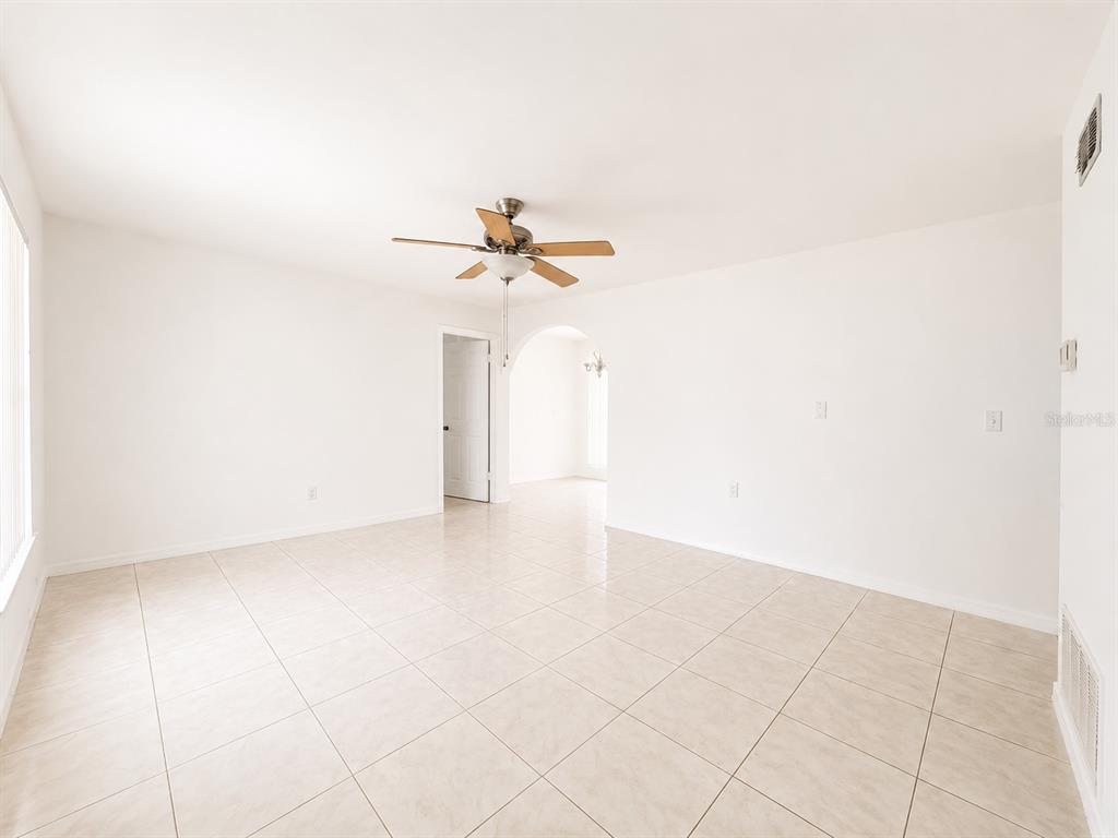 An empty room with white walls, light-colored tile flooring, and a ceiling fan — 714 WEST COURT, LONGWOOD, FL