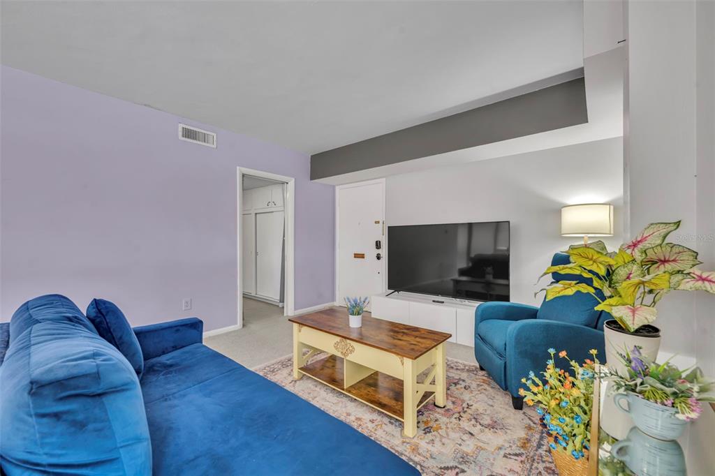 A living room features a blue sofa, a blue armchair, a coffee table, and a television — 311 E MORSE BOULEVARD UNIT 6-12, WINTER PARK, FL