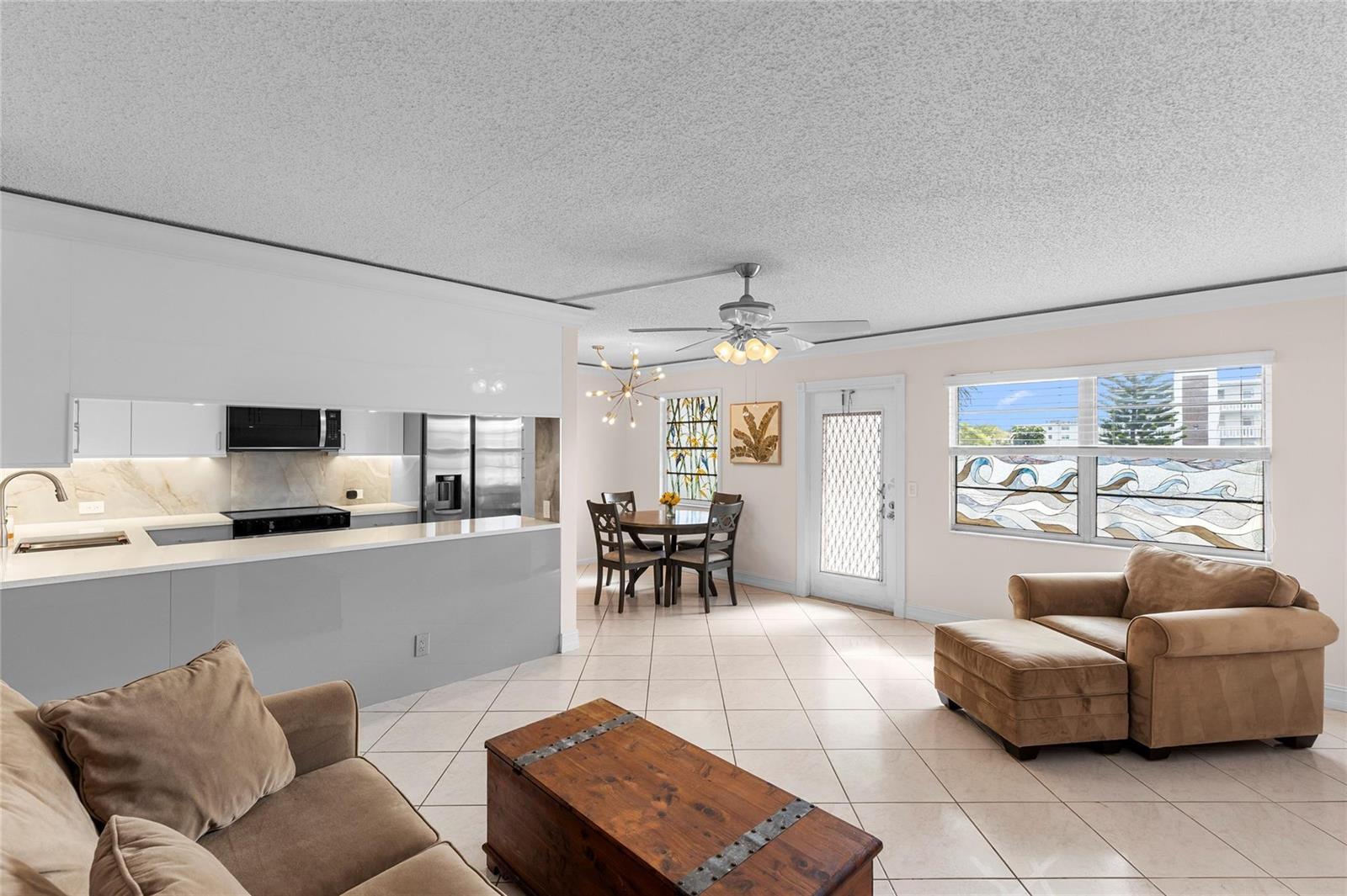 A sunroom with tile flooring and large windows overlooking a lake and apartment buildings — 2122 Cambridge F # 2122, Deerfield Beach FL 33442, DEERFIELD BEACH, FL