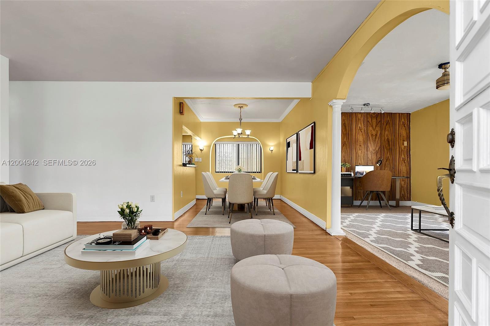 A living room with a dining area and office space features yellow walls and wood floors — 3694 NW 20th St, Miami FL 33142, MIAMI, FL