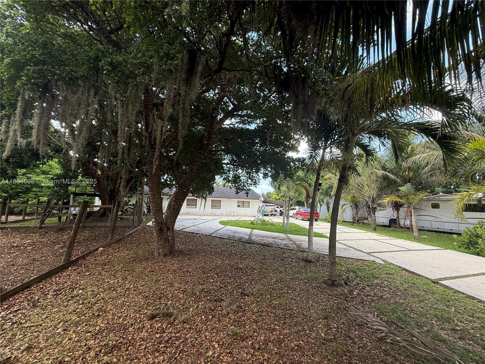 A driveway leads to a white house shaded by large trees with hanging moss — 15765 SW 206th Ave, Miami FL 33187, MIAMI, FL