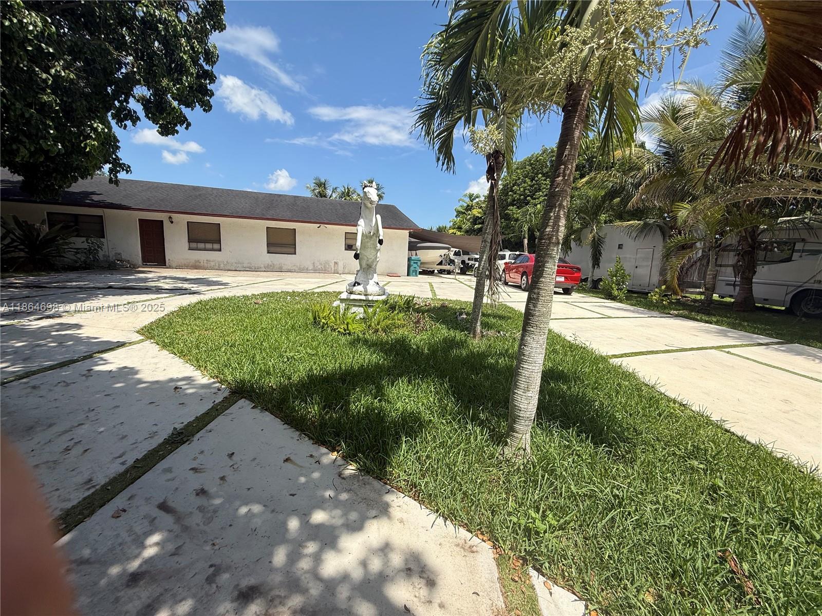 A white house with a horse statue in the front yard and a paved driveway — 15765 SW 206th Ave, Miami FL 33187, MIAMI, FL