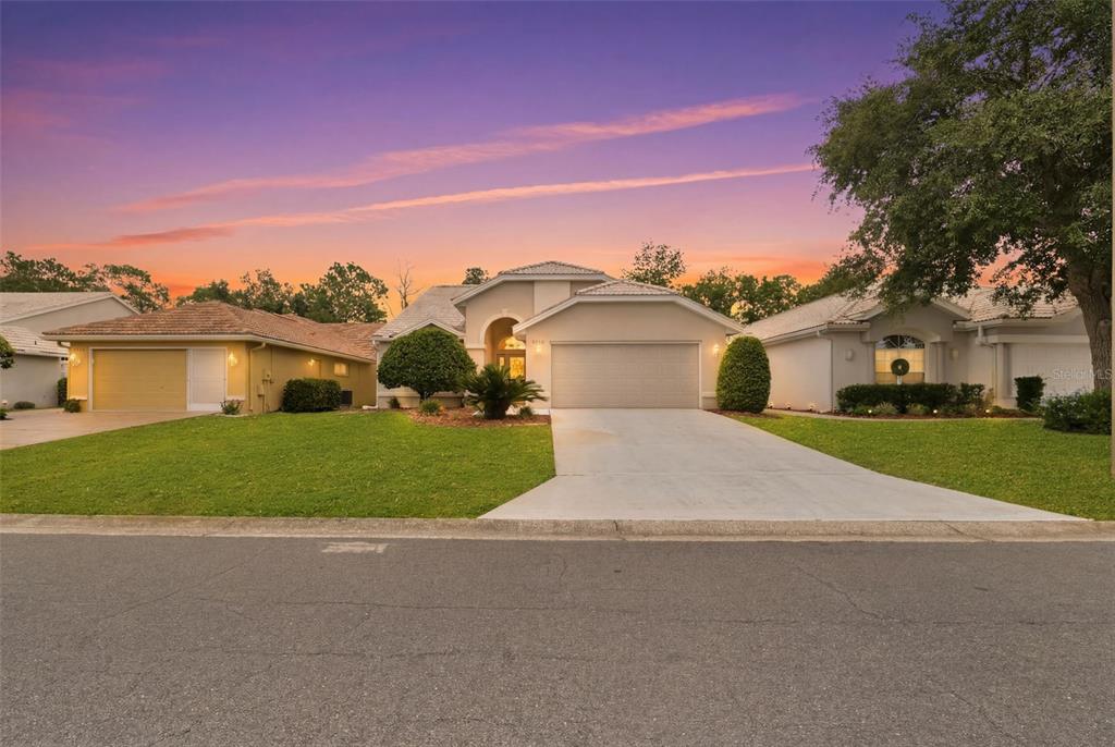A single-story house with a two-car garage and a concrete driveway at sunset — 9450 MISSISSIPPI RUN, WEEKI WACHEE, FL