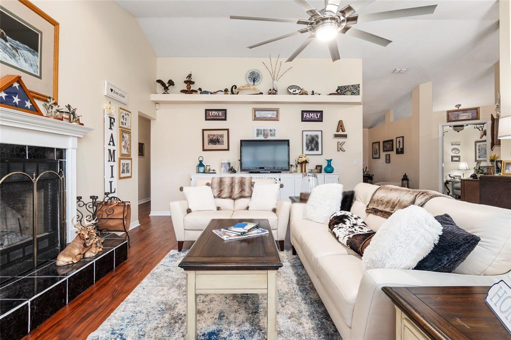 A living room features a fireplace, a television, a ceiling fan, and white sofas — 275 SE 34TH PLACE, OCALA, FL