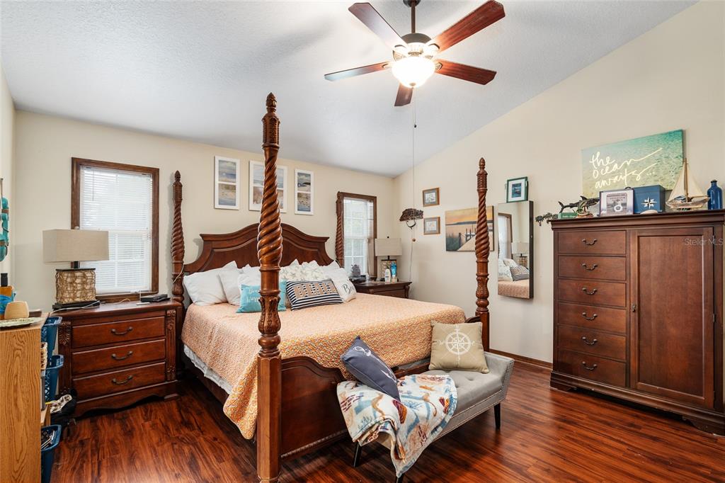 A bedroom features a four-poster wooden bed, a large dresser, and wood-look flooring — 275 SE 34TH PLACE, OCALA, FL