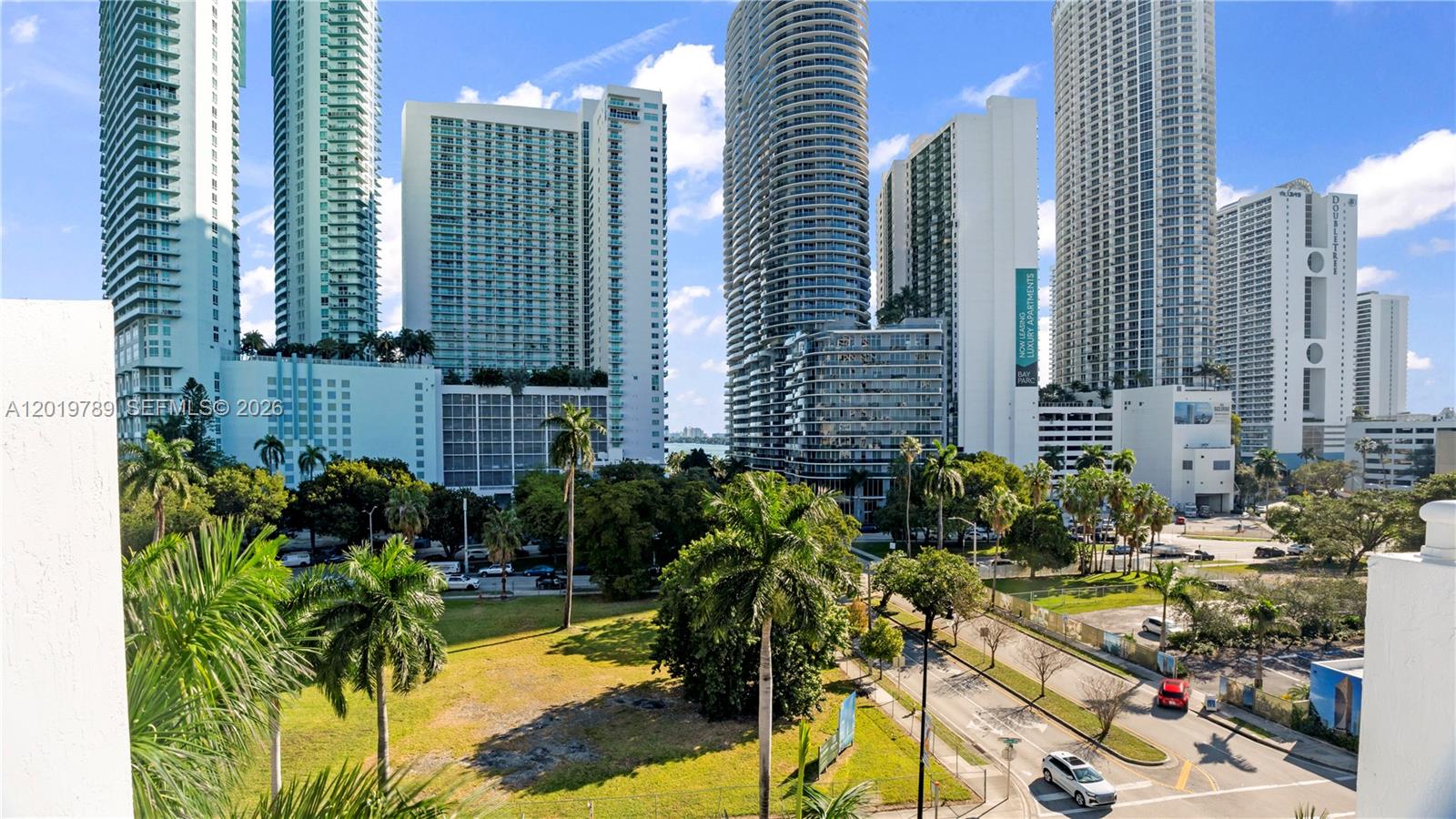 An elevated view of a city skyline featuring multiple high-rise buildings and palm trees — 275 NE 18th st # 1606, Miami FL 33132, MIAMI, FL