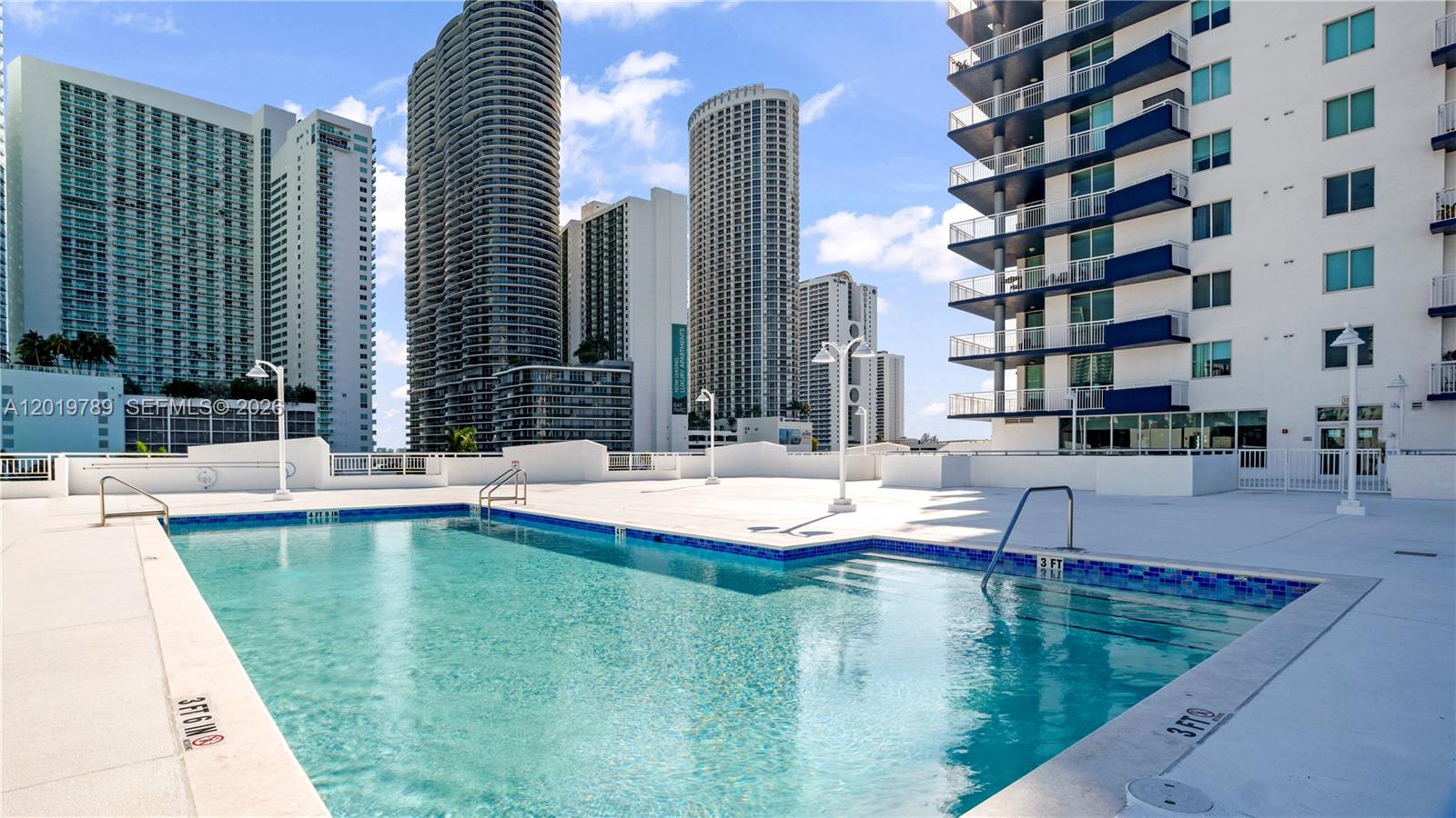 A swimming pool on a rooftop deck is surrounded by high-rise apartment buildings — 275 NE 18th st # 1606, Miami FL 33132, MIAMI, FL