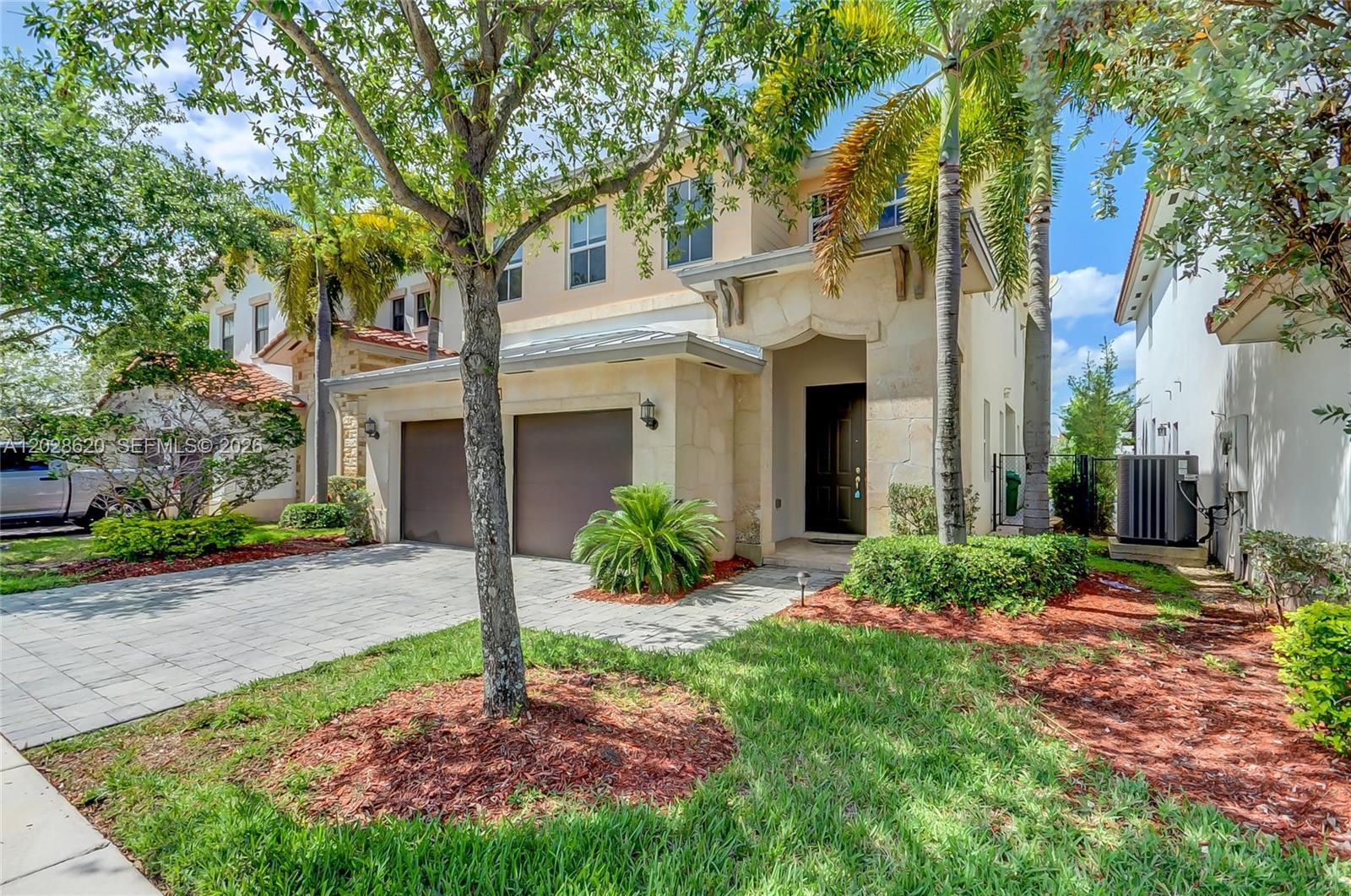 A patio with wicker furniture and a wooden pergola overlooks a lake and houses — 10555 NW 69th Ter, Doral FL 33178, DORAL, FL