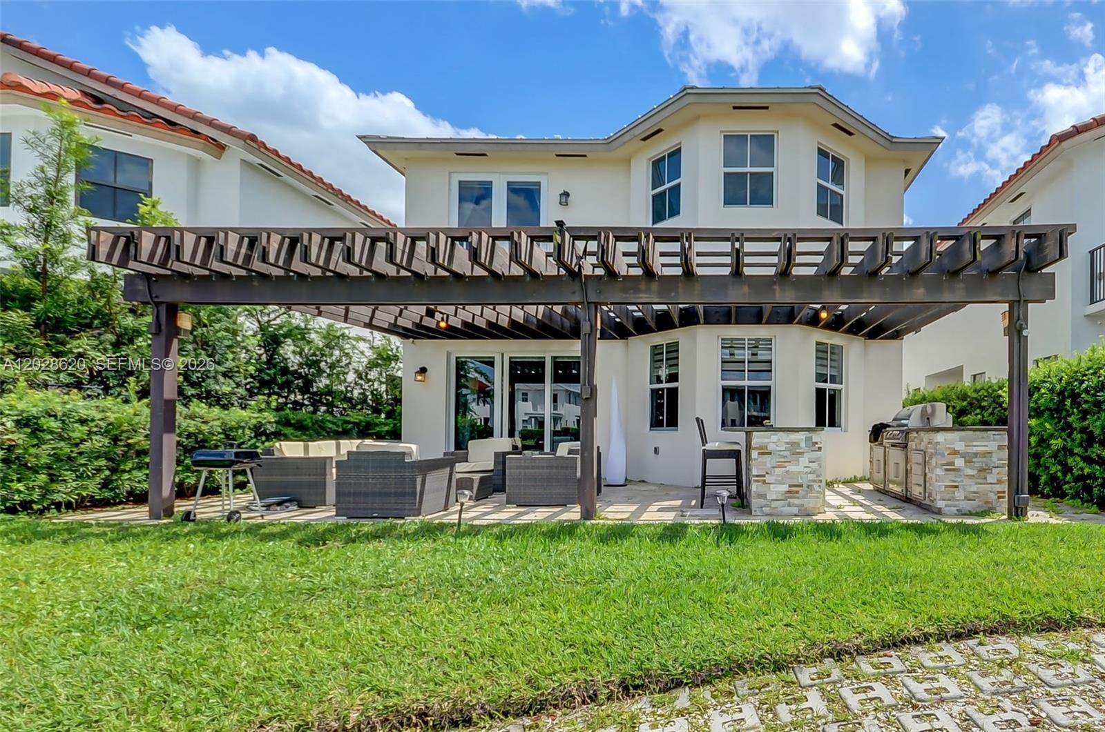 A two-story house with a two-car garage and a paved driveway under a blue sky — 10555 NW 69th Ter, Doral FL 33178, DORAL, FL
