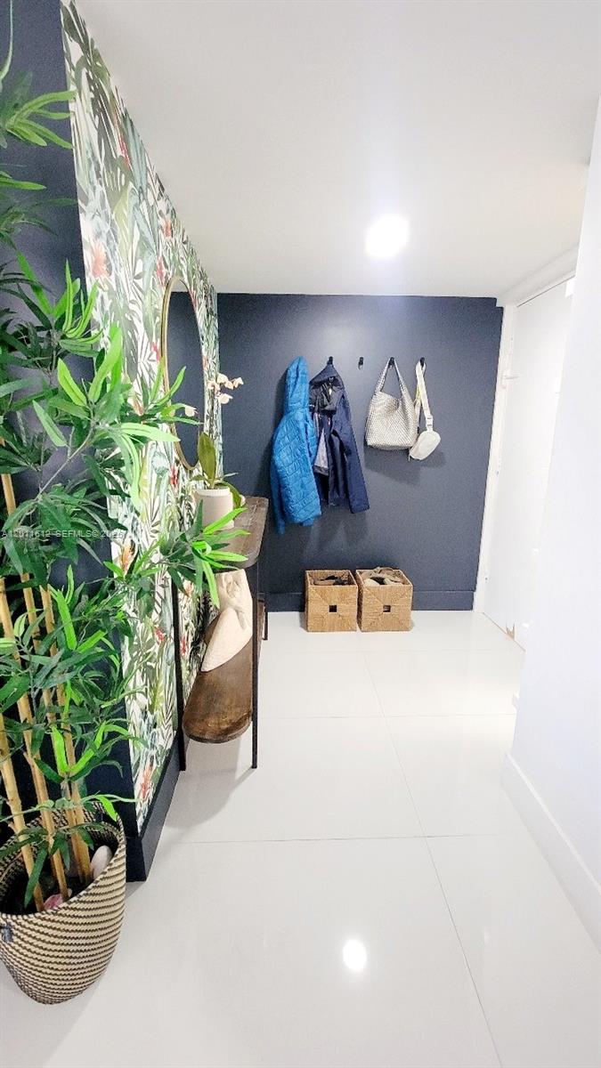 An entryway features a dark accent wall with coat hooks, a console table, and wallpaper — 250 Galen Dr # 43, Key Biscayne FL 33149, KEY BISCAYNE, FL