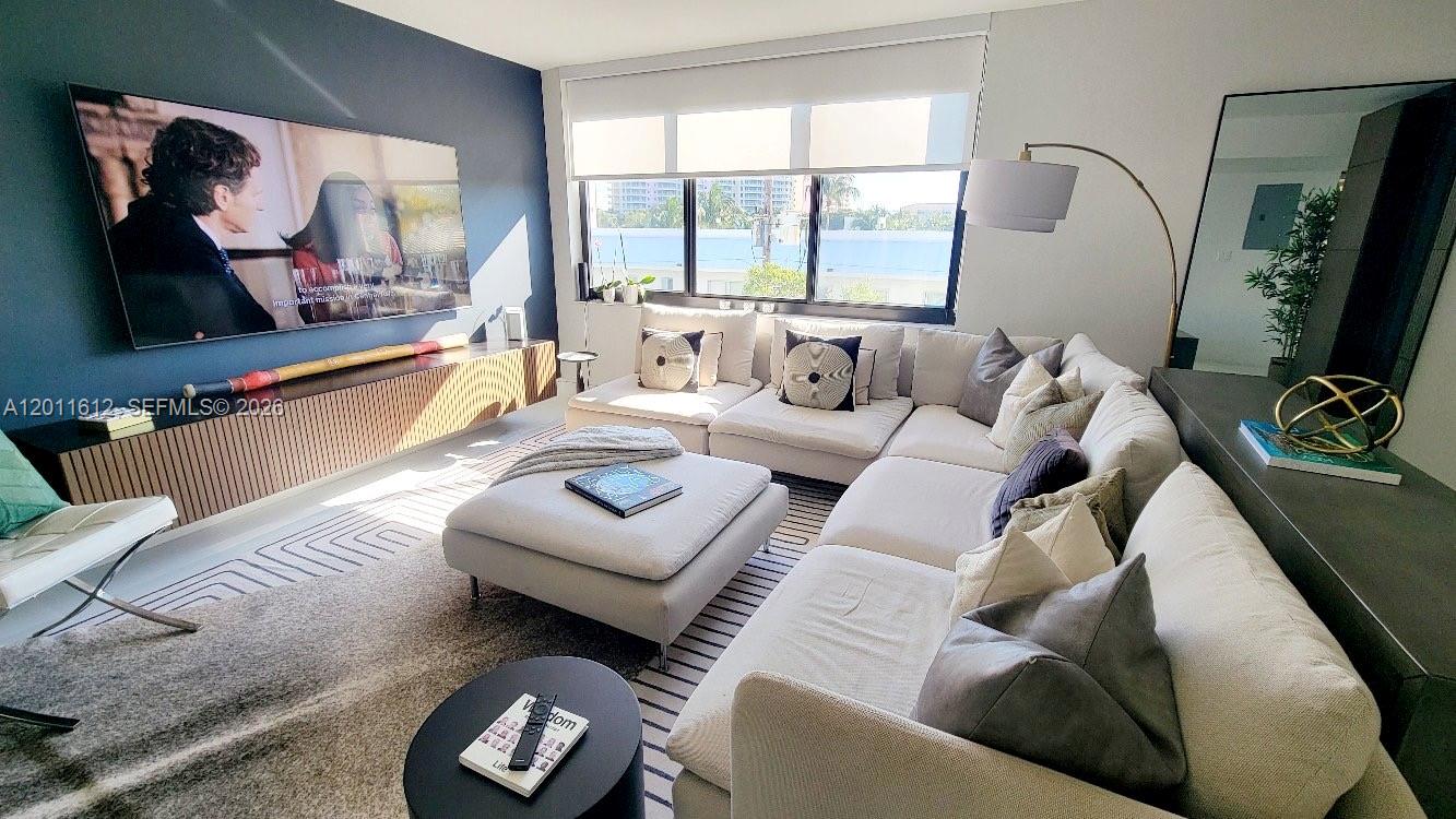 A modern living room features a large sectional sofa, a wall-mounted television, and floor-to-ceiling windows — 250 Galen Dr # 43, Key Biscayne FL 33149, KEY BISCAYNE, FL