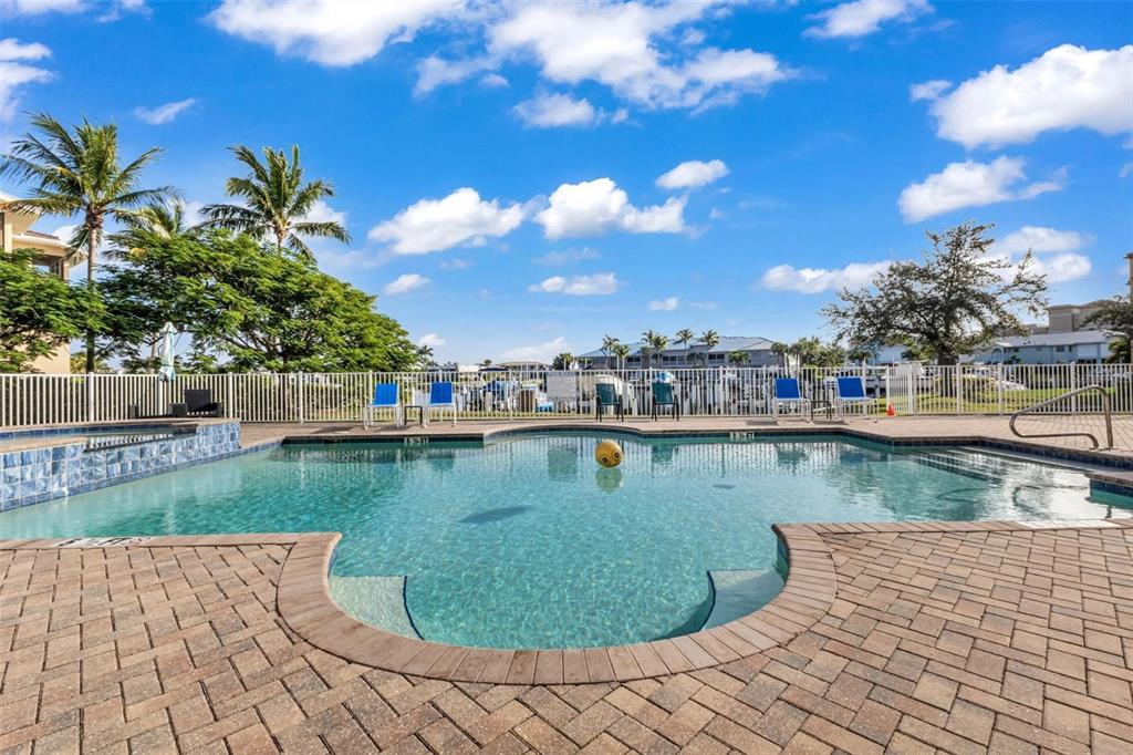 An aerial view shows a multi-story apartment complex with a pool and boat docks — 3322 PURPLE MARTIN DRIVE UNIT 125, PUNTA GORDA, FL