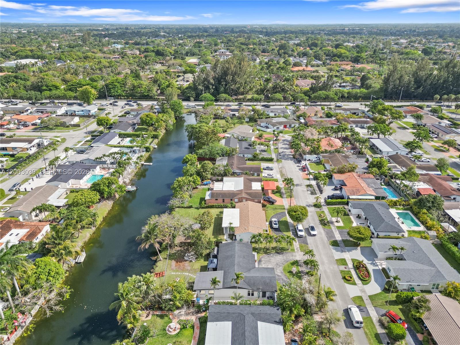 An aerial view shows a residential neighborhood with houses lining a canal and street — 3921 SW 124th Ct, Miami FL 33175, MIAMI, FL