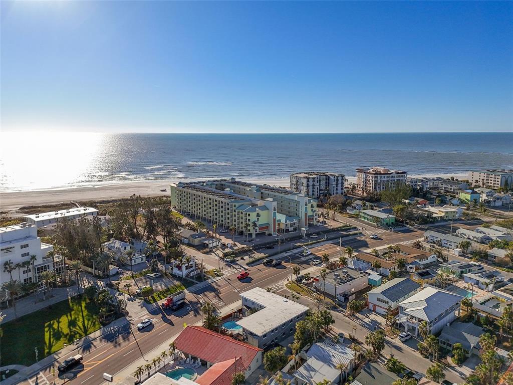 An aerial view shows a large beachfront hotel complex surrounded by residential buildings and streets — 12000 GULF BOULEVARD UNIT 501-W, TREASURE ISLAND, FL
