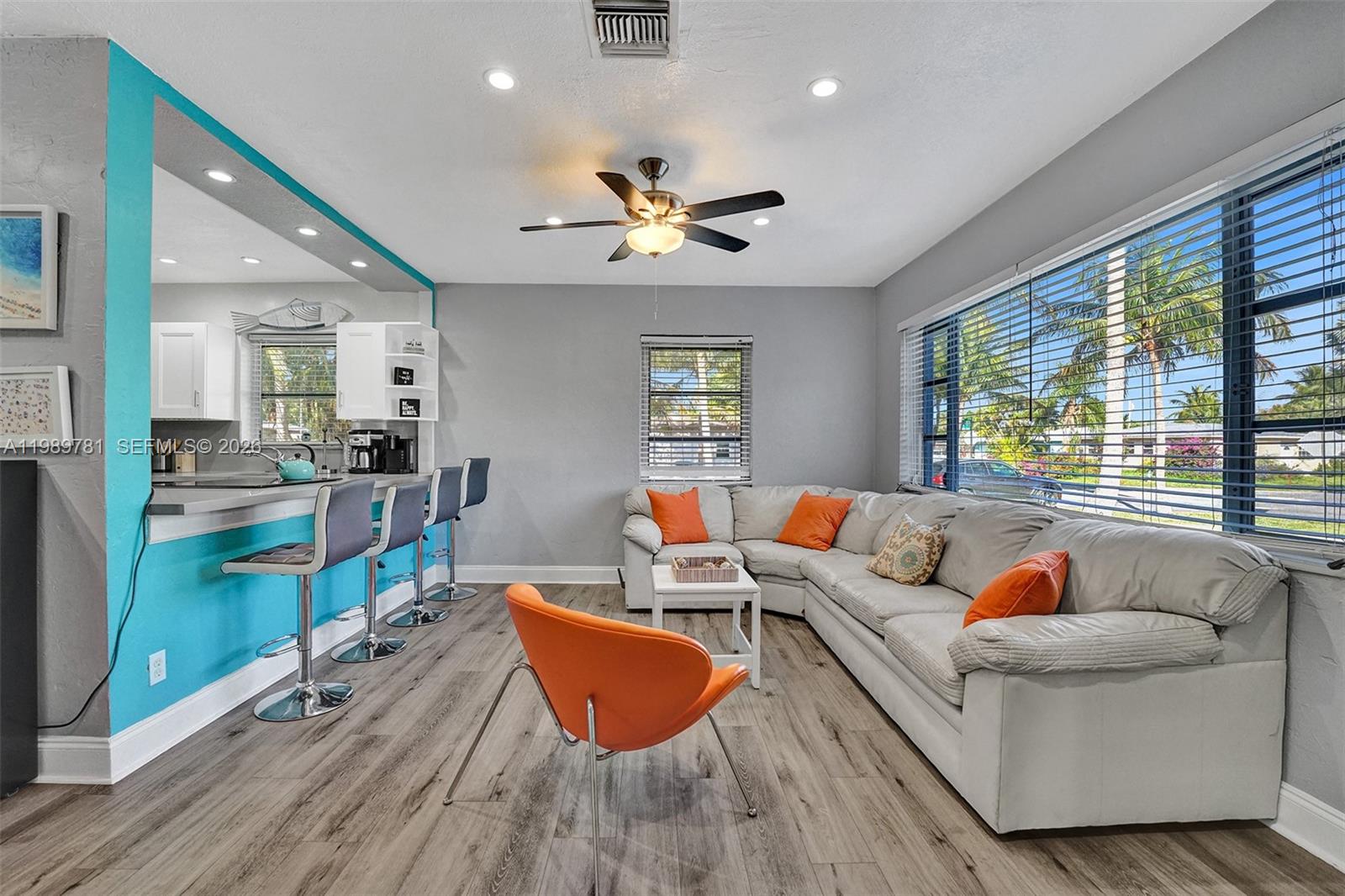 A living room features a sectional sofa, orange accent chairs, and a breakfast bar — 529 NW 8th St, Dania Beach FL 33004, DANIA BEACH, FL