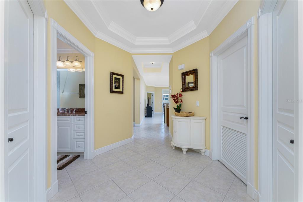 A bright foyer features yellow walls, white trim, tile flooring, and a tray ceiling — 3311 WOOD THRUSH DRIVE UNIT 113, PUNTA GORDA, FL