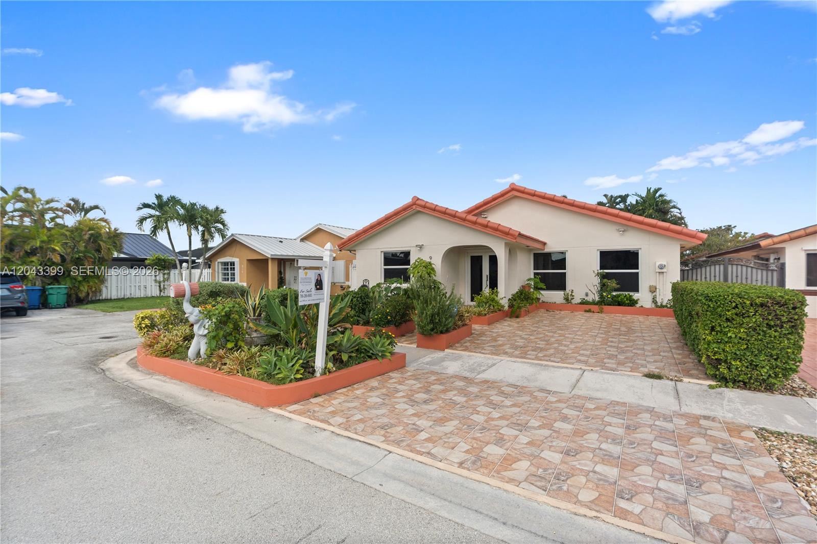 A single-story house with a tiled roof, paved driveway, and a landscaped front garden — 910 SW 140th Ave, Miami FL 33184, MIAMI, FL