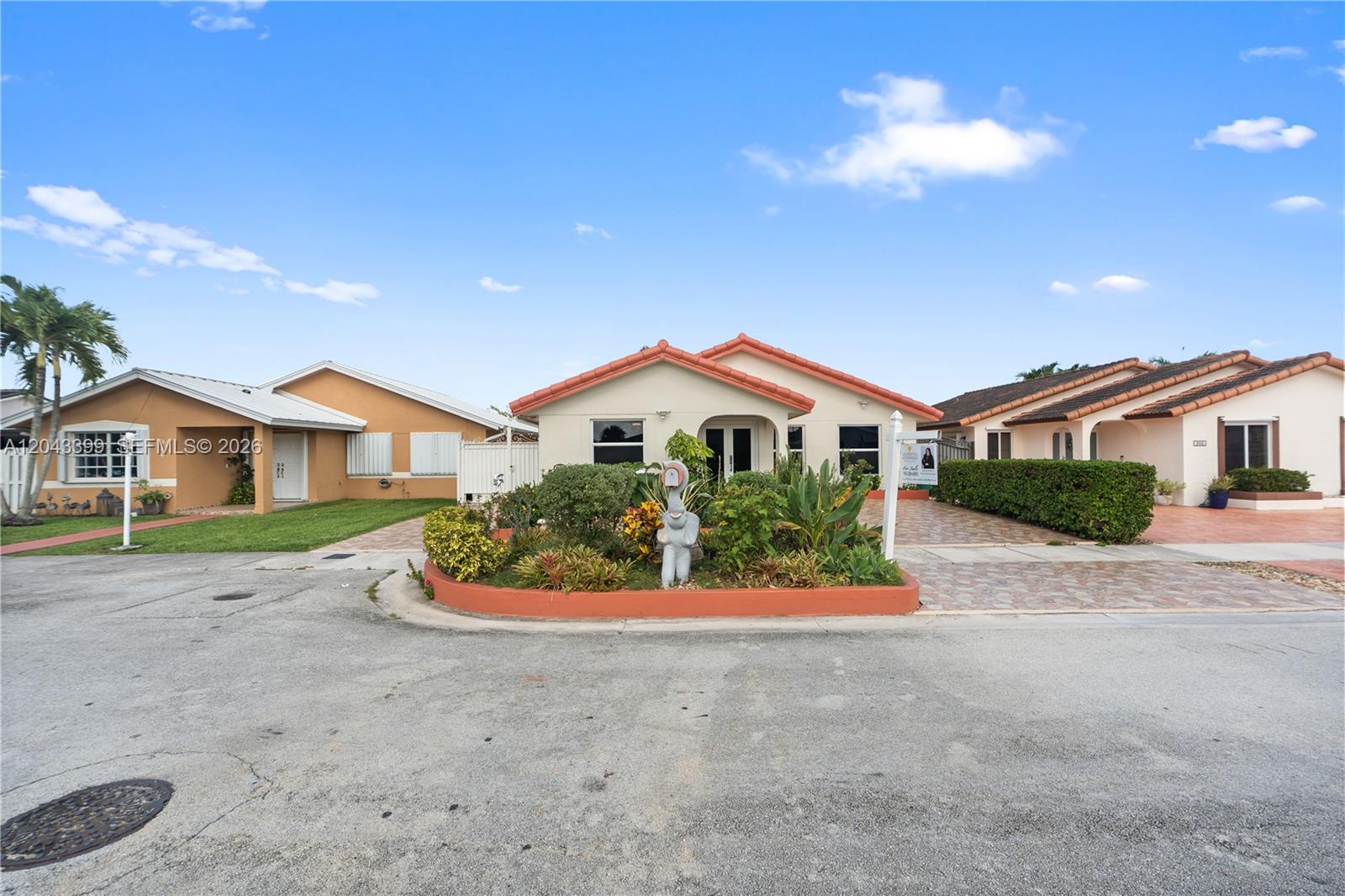 A single-story house with a tiled roof and a landscaped front garden sits on a street — 910 SW 140th Ave, Miami FL 33184, MIAMI, FL