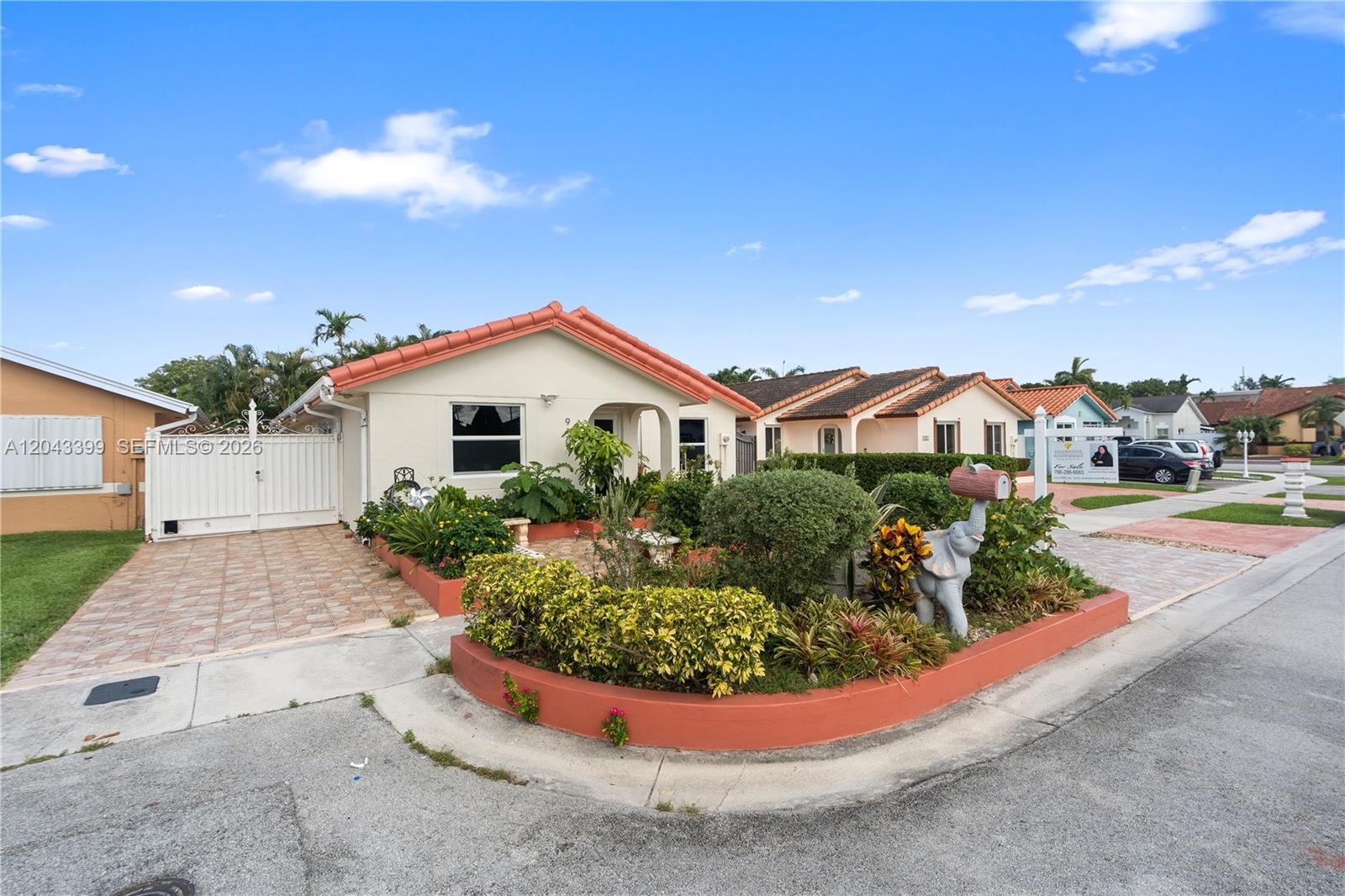 A single-story house with a terracotta roof, a paved driveway, and a landscaped front garden — 910 SW 140th Ave, Miami FL 33184, MIAMI, FL