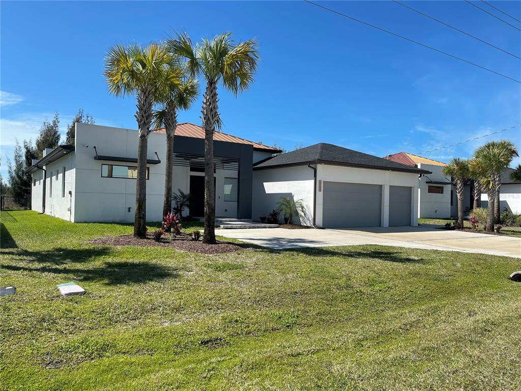 A modern single-story house with a white exterior, a gray garage, and several palm trees — 2106 SW 4TH STREET, CAPE CORAL, FL