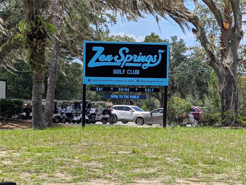 A blue sign for Zen Springs Golf Club stands in front of parked golf carts — 20167 SW 81ST STREET, DUNNELLON, FL
