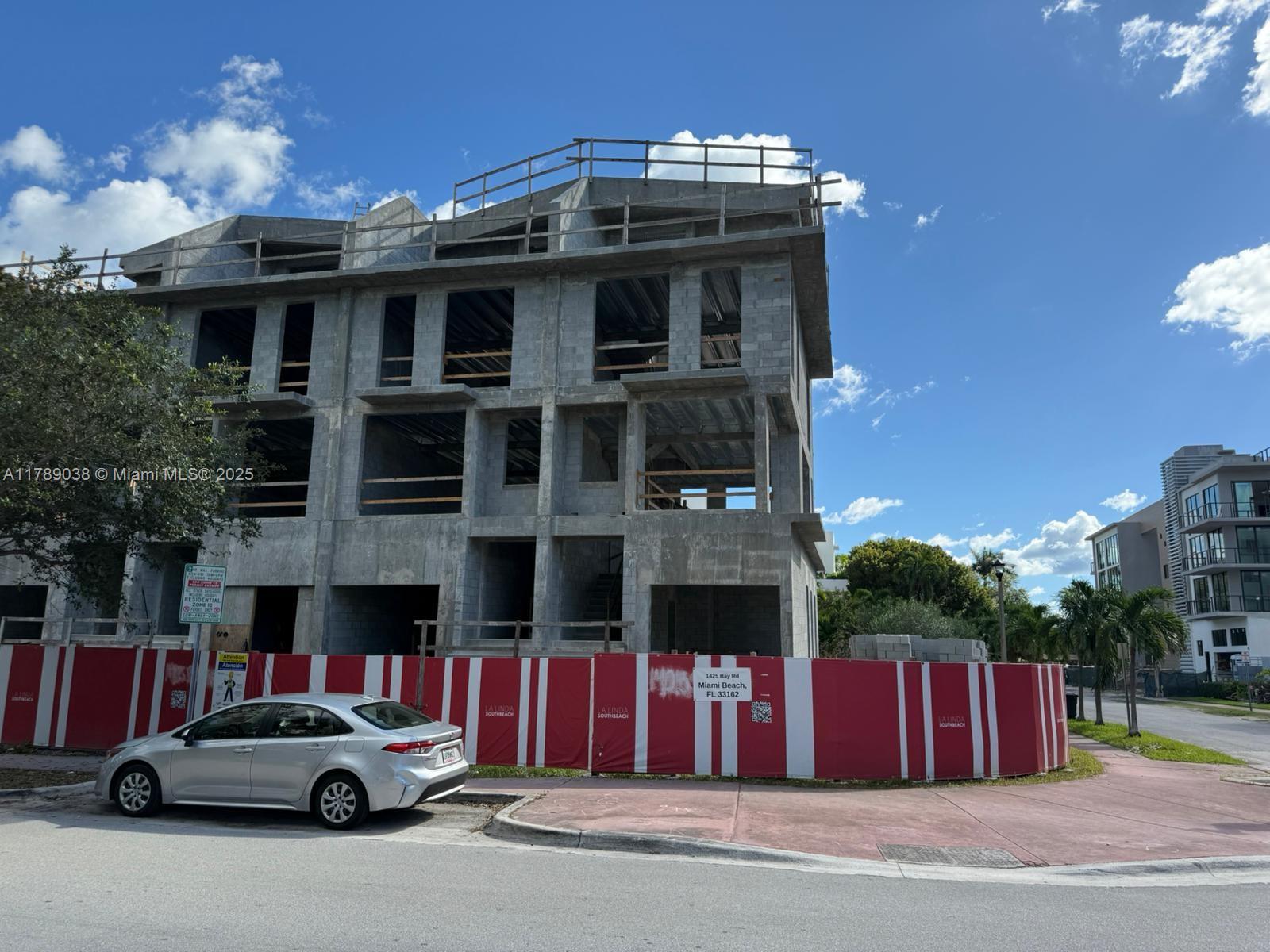 A multi-story concrete building under construction is surrounded by a red and white construction fence — 1425 Bay Rd, Miami Beach FL 33139, MIAMI BEACH, FL