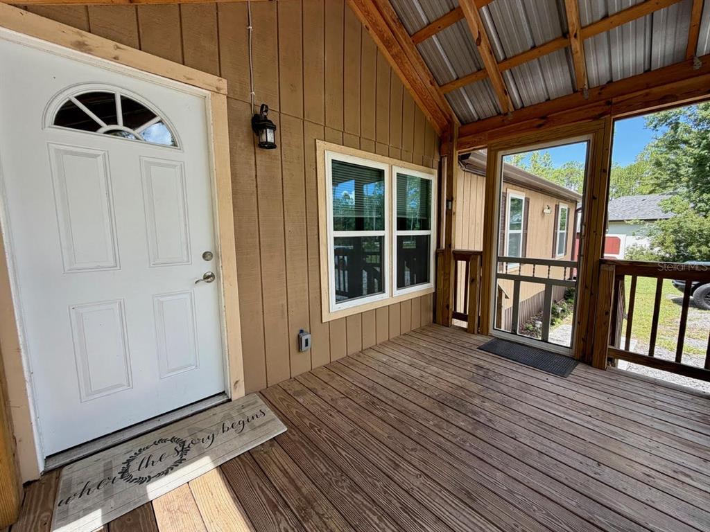 A single-story manufactured home with a screened front porch and a metal roof — 5171 MAHOGANY BOULEVARD, BUNNELL, FL