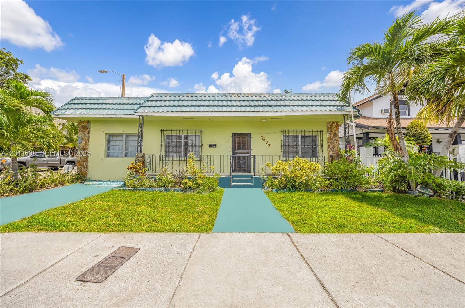 A single-story house with a green facade, a tiled roof, and a front porch — 1477 NW 2nd St, Miami FL 33125, MIAMI, FL