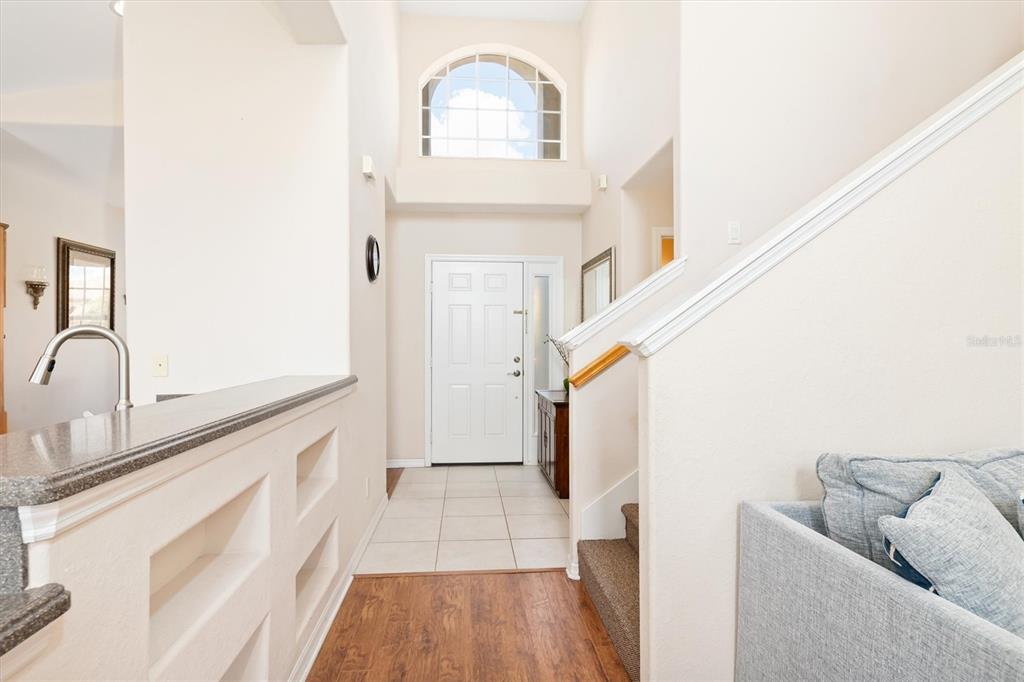 An entryway features a white front door, a high arched window, and a staircase — 6918 74TH STREET CIRCLE E, BRADENTON, FL