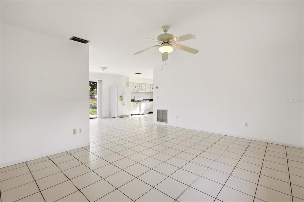 A bright, open-concept living and dining area features white walls and light-colored tile flooring — 10894 GRANITE STREET, BOCA RATON, FL