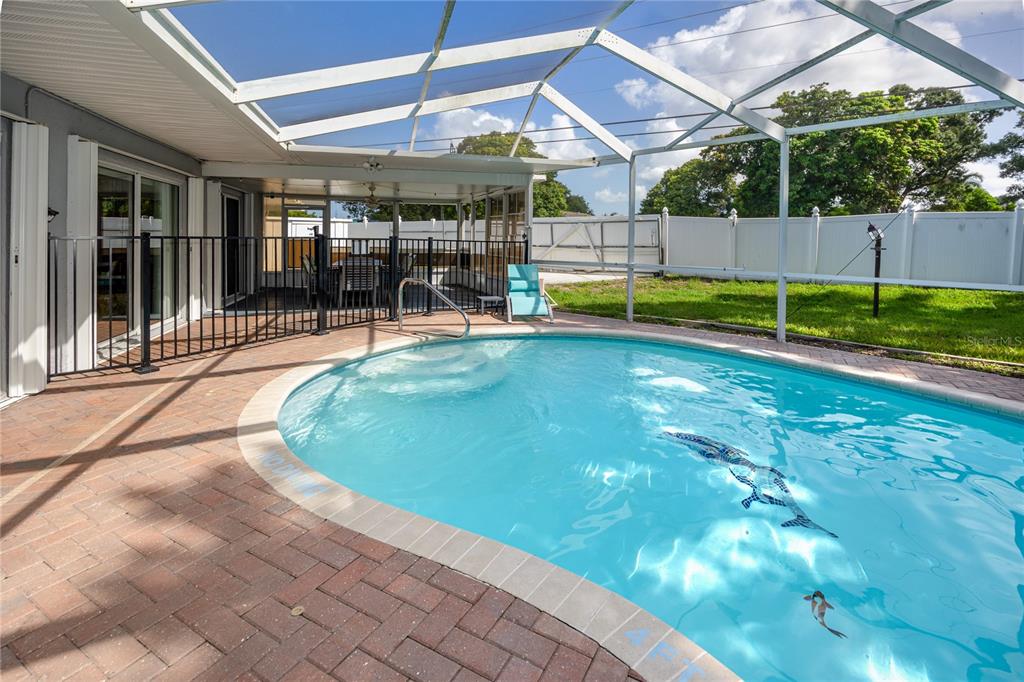 A swimming pool with a screen enclosure and a brick patio in a backyard — 12291 MONARCH CIRCLE, SEMINOLE, FL